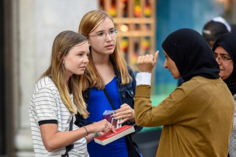 two teen girls sharing the gospel with women